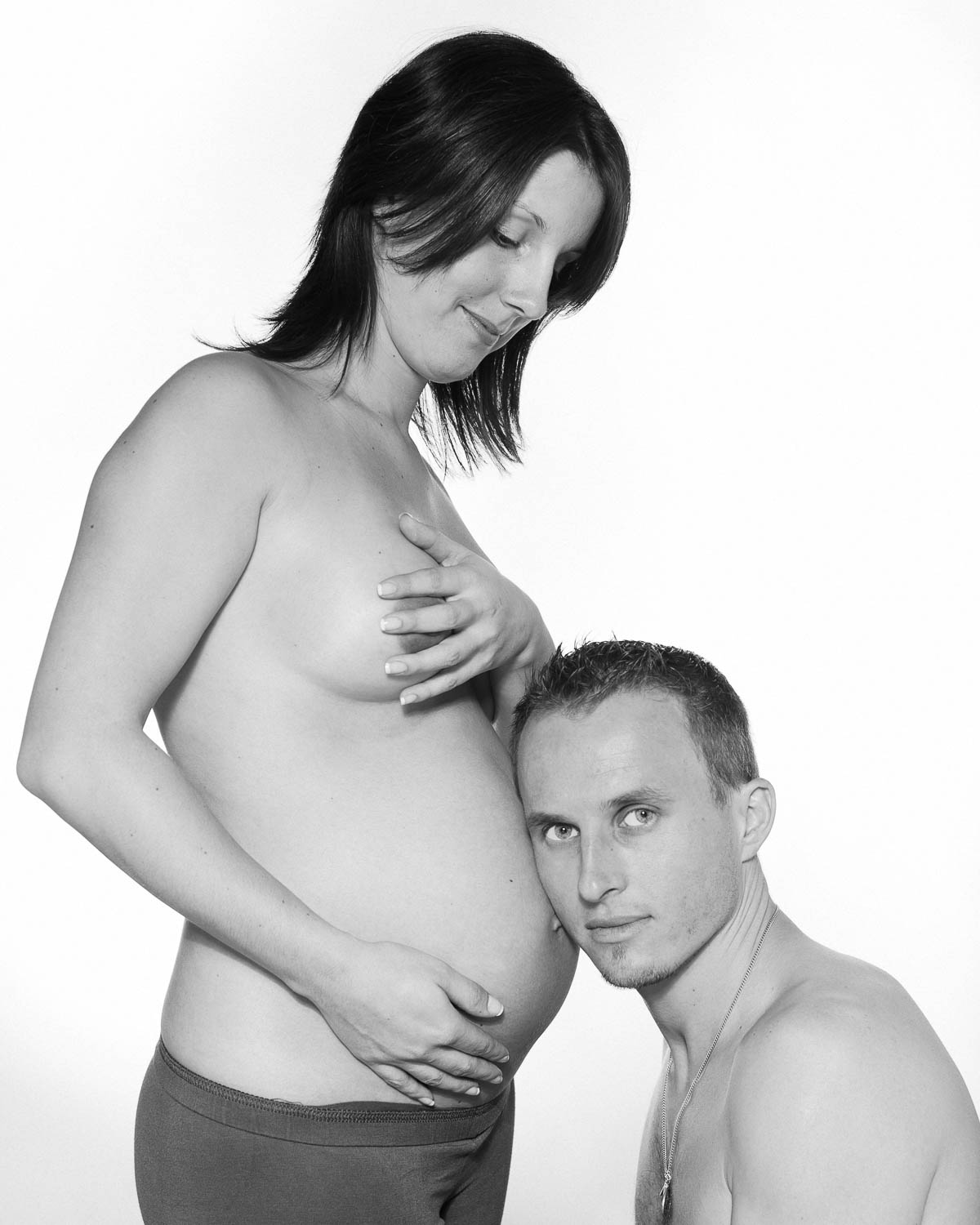  portrait noir et blanc maternité de couple sur fond blanc en studio 