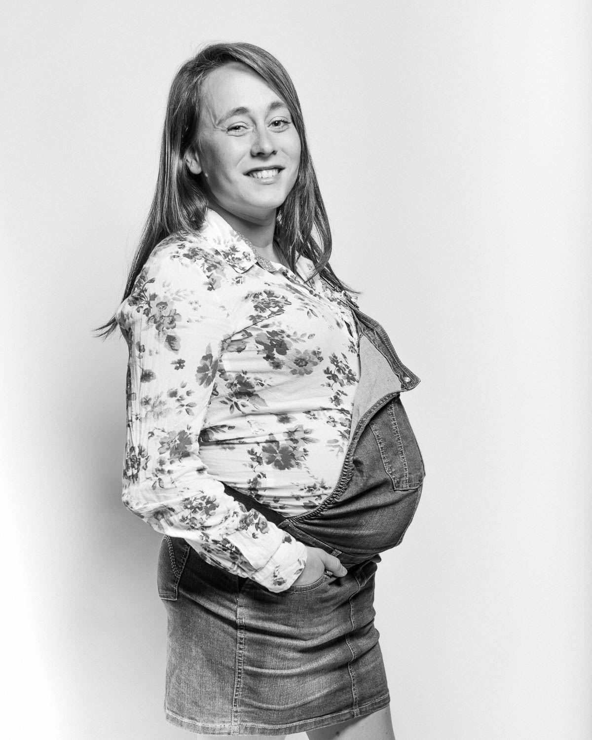  portrait noir et blanc d'une femme enceinte sur fond blanc en studio 