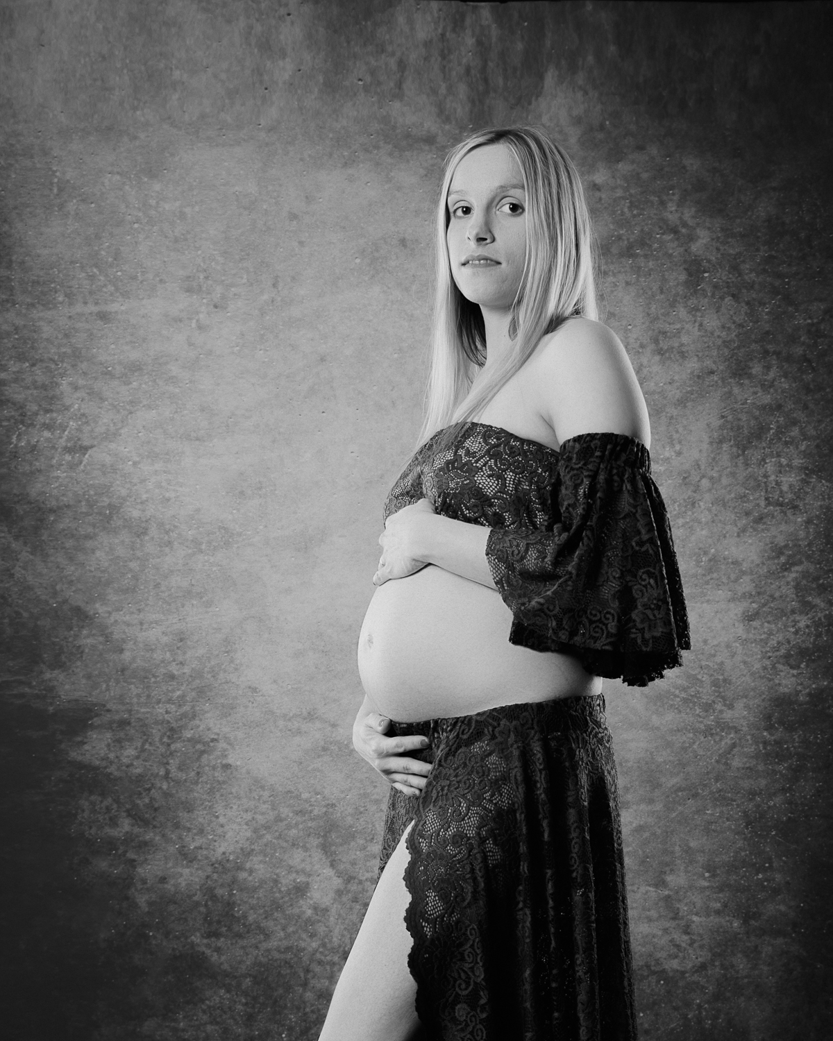  portrait noir et blanc d'une femme enceinte sur fond noir en studio 