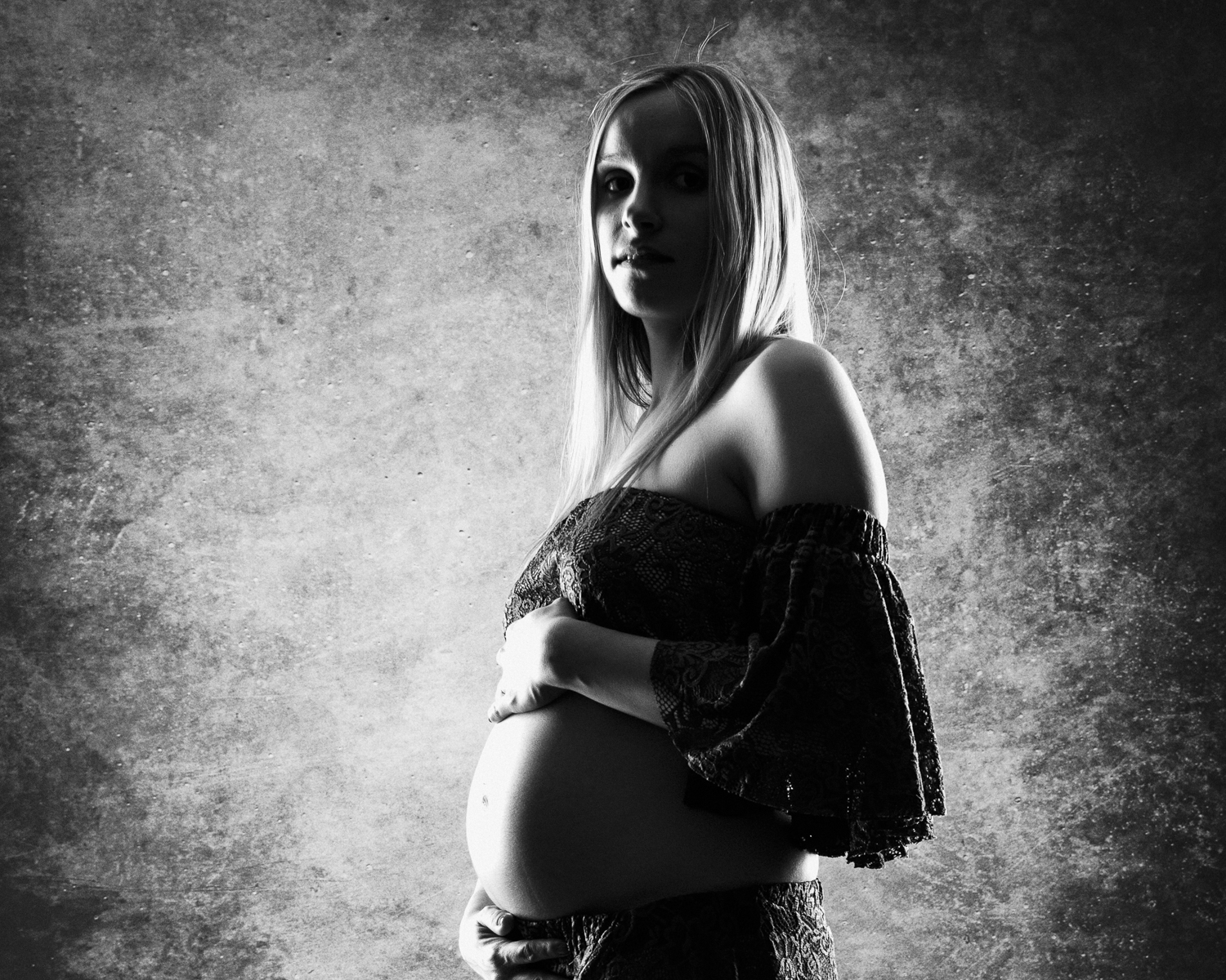  portrait noir et blanc d'une femme enceinte sur fond noir en studio 