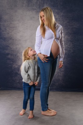 pregnant woman with small daughter in studio 