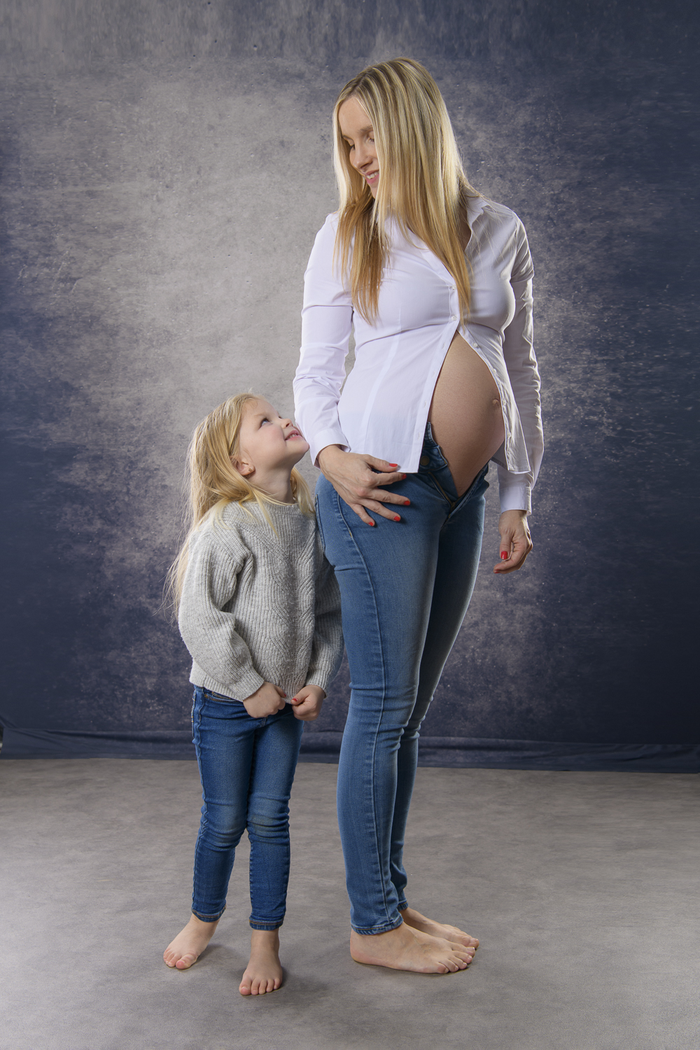 pregnant woman with little daughter in studio