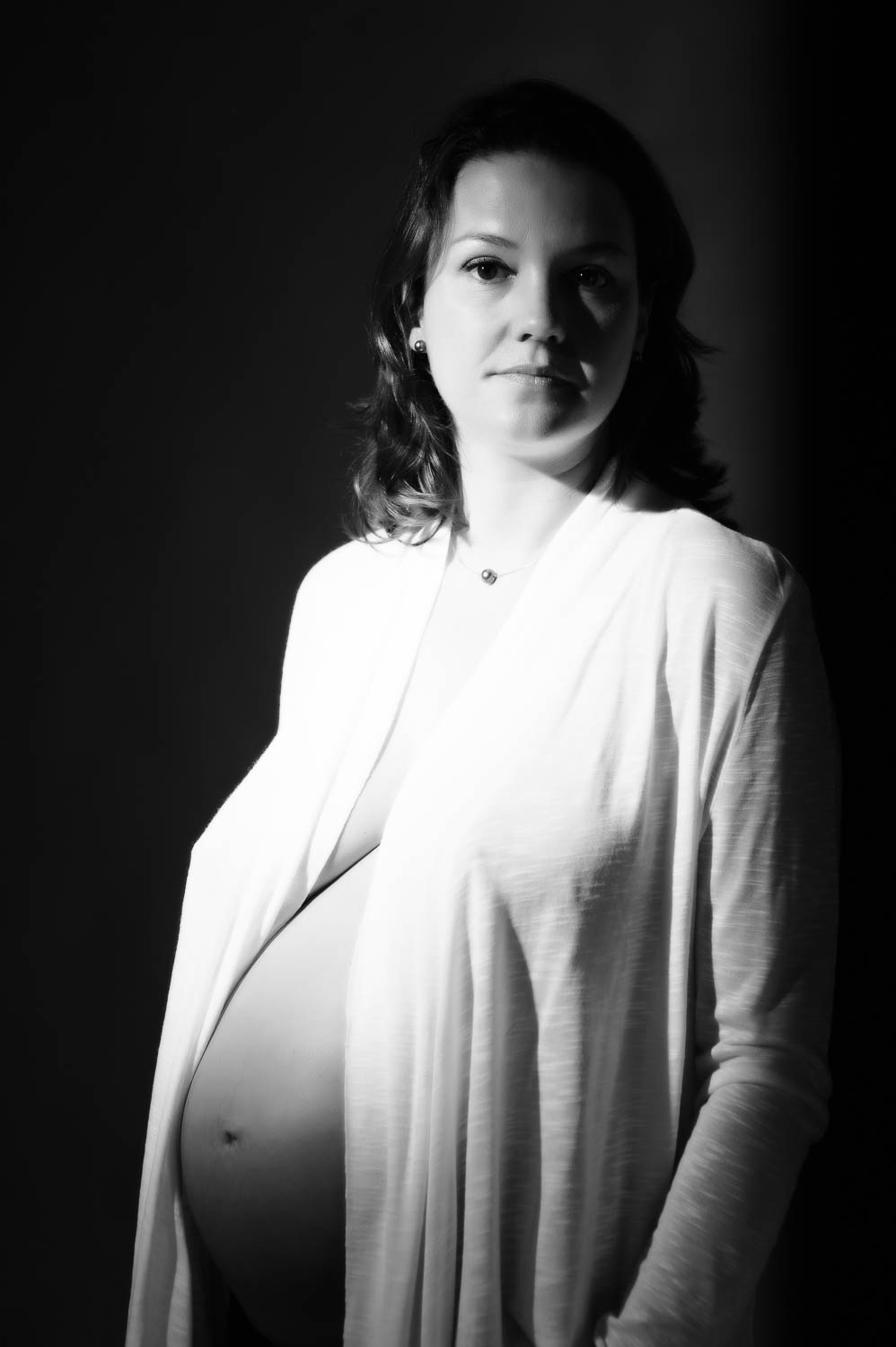 Pregnant woman in studio on black background
